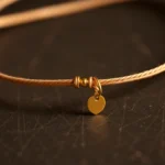 Zlota bransoletka na sznurku being worn on wrist by model, highlighting fine details and gold